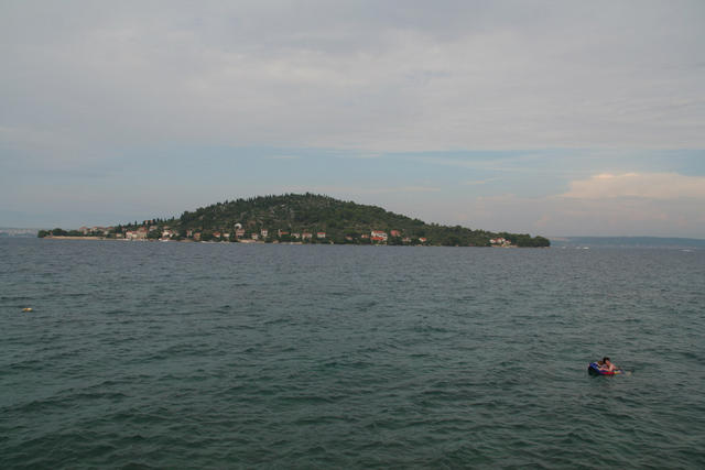 Sosednji otok Ošljak z nekaj hišami, kjer trajekt na hitro ustavi, da grejo potniki dol
